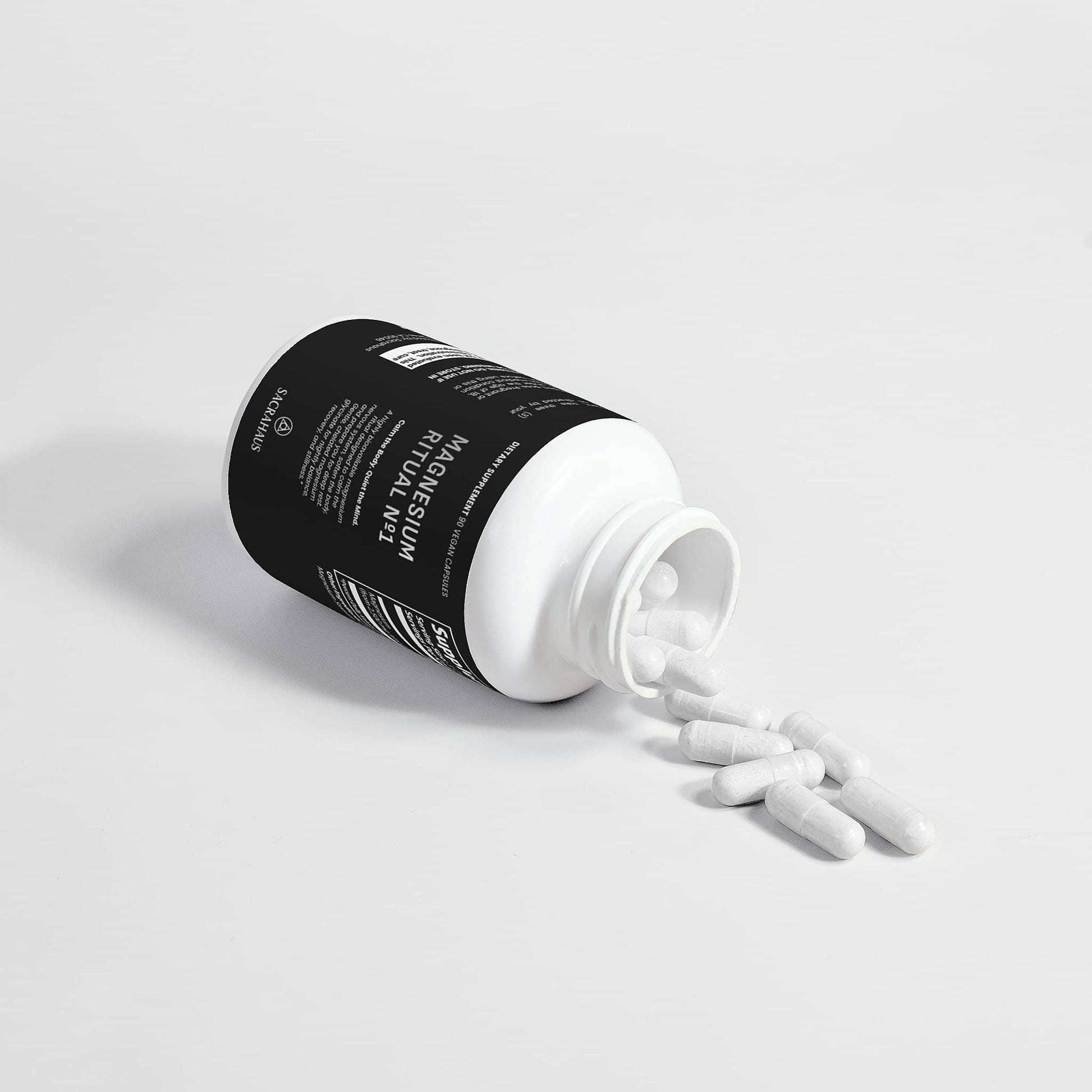 SACRAHAUS magnesium glycinate vegan supplement with white capsules spilling from a black bottle