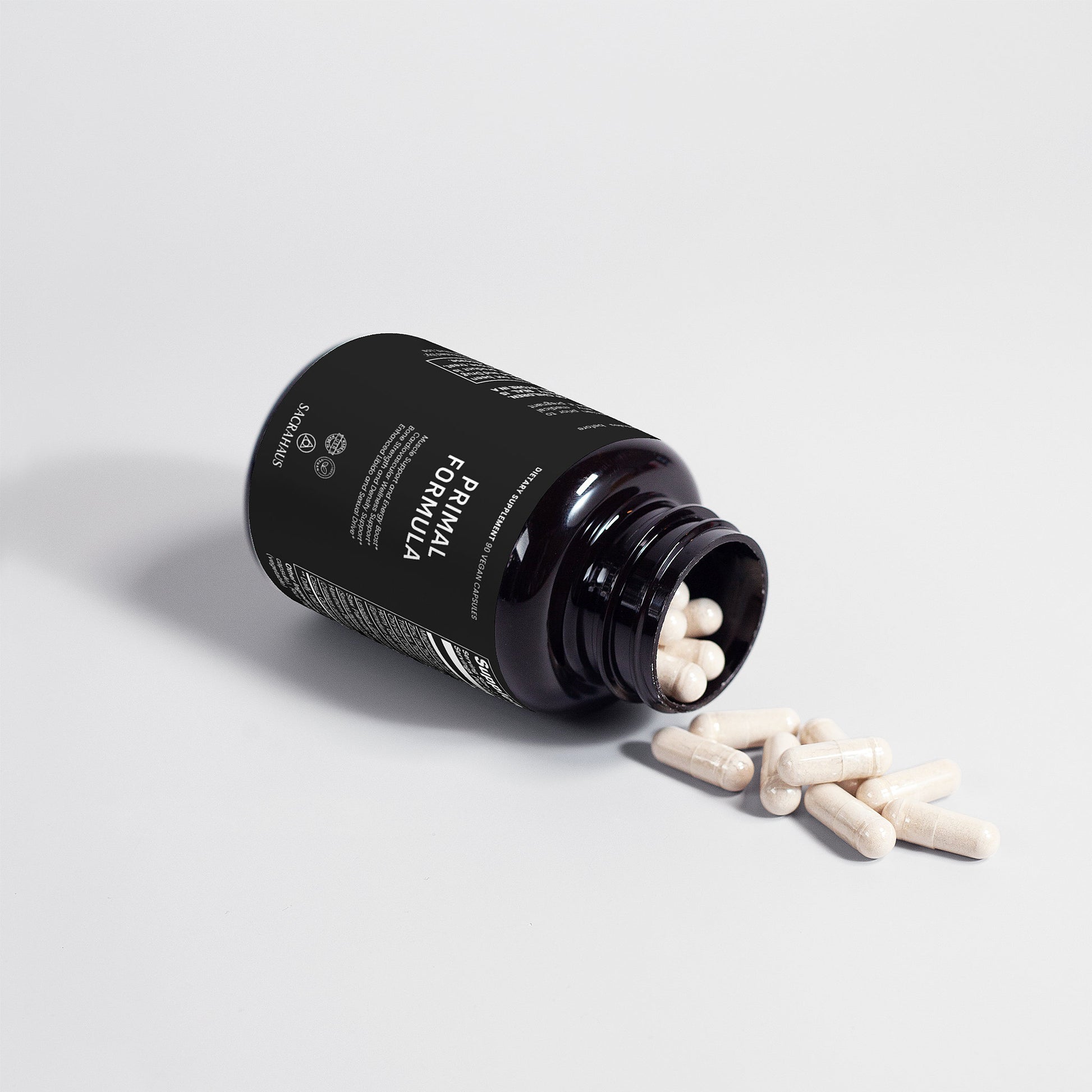 SACRAHAUS vegan energy supplement bottle with spilled capsules for wellness and vitality